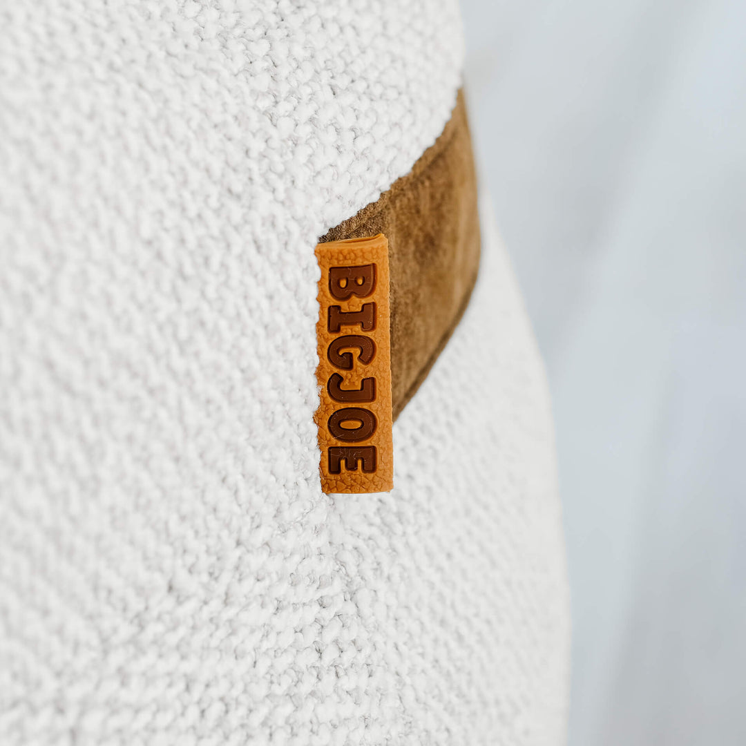 Close-up of a Big Joe logo on a textured white surface #color_sandstone-textured-boucle