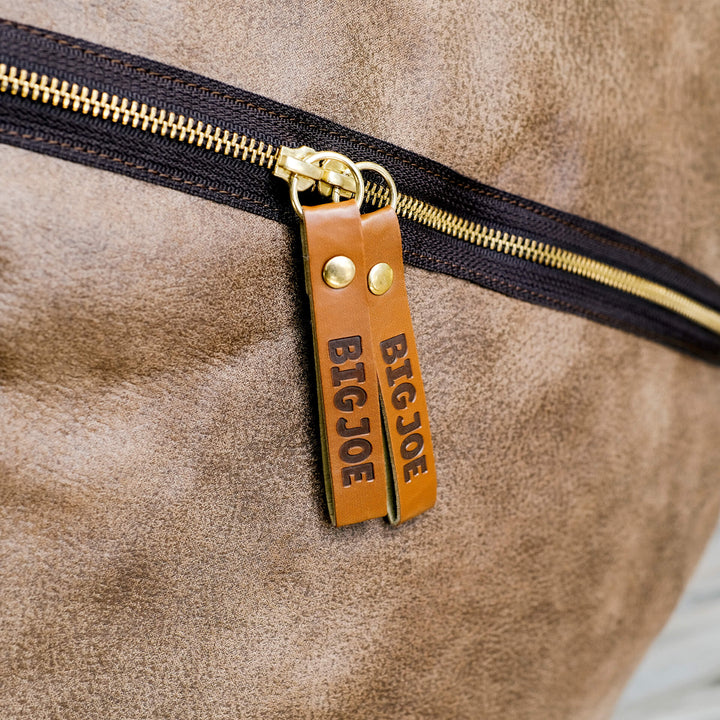Close-up of a brown leather bag with a gold zipper and 'BIG JOE' label. #color_coffee-soft-vegan-leather