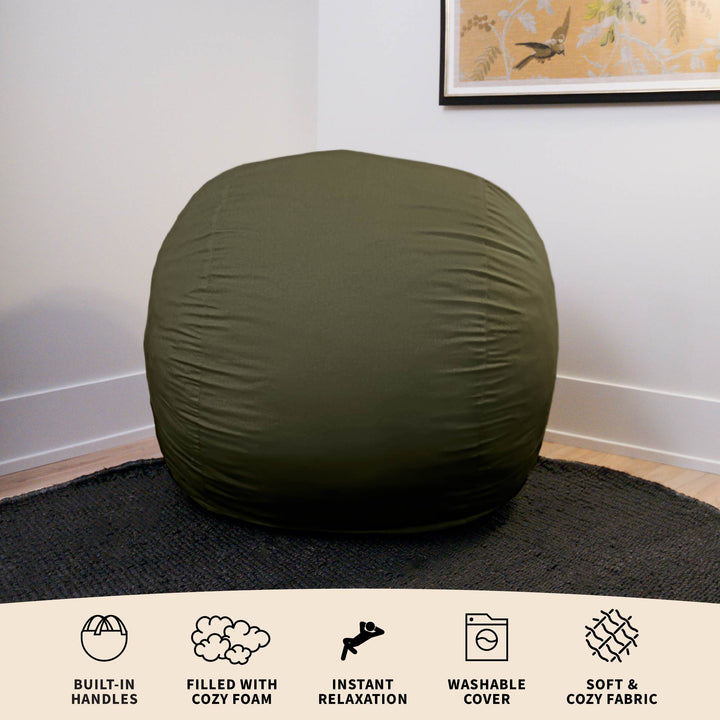 Green bean bag chair on a black rug with text describing features. #color_forest-green-velveteen