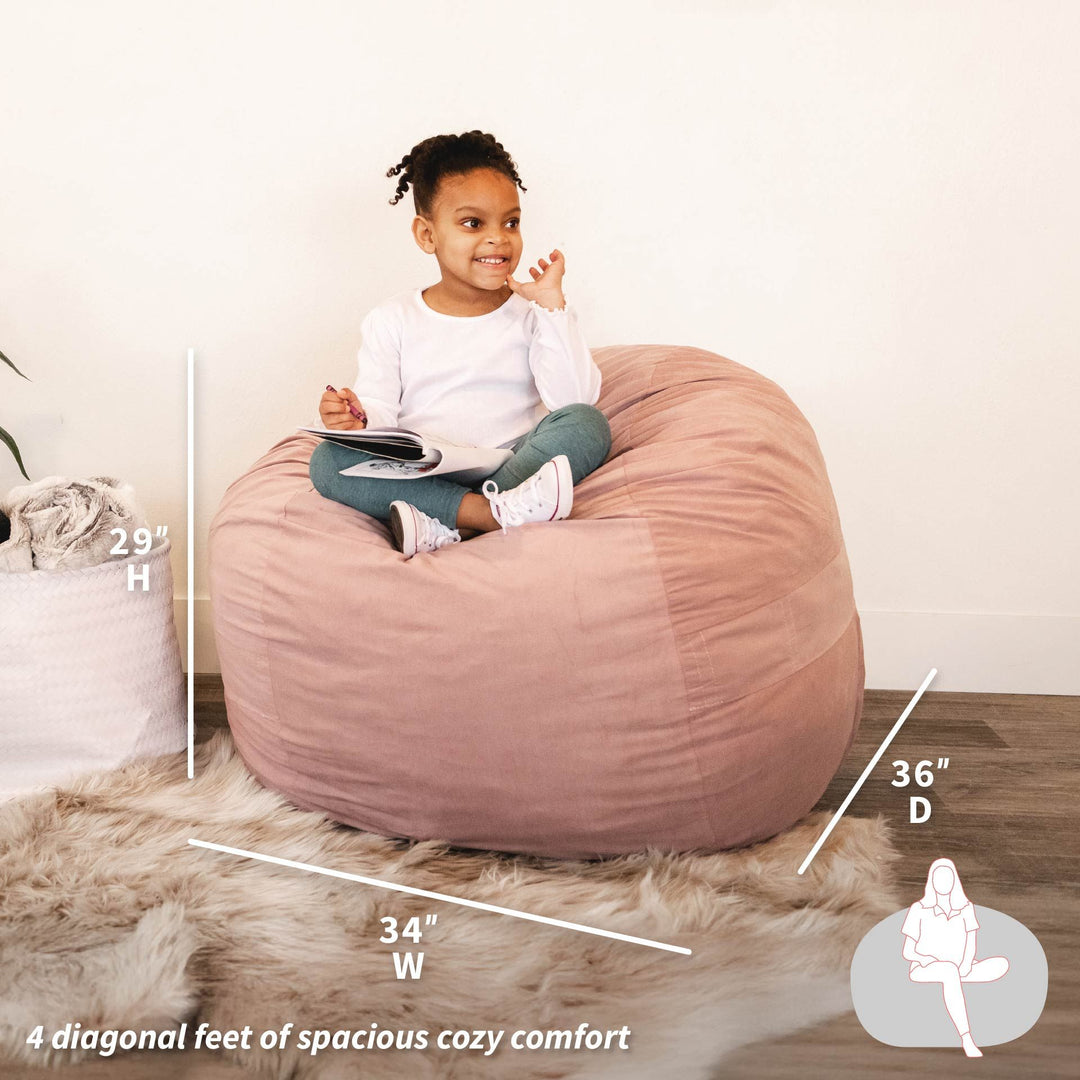 Child sitting on a pink bean bag chair with measurements displayed #color_desert-rose-brushed-denim