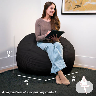Woman sitting on a black bean bag chair with measurements displayed 