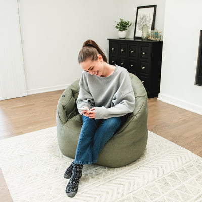 Woman watching phone in Milano with Vibe in Olive Green vegan leather #color_olive-green-vegan-leather