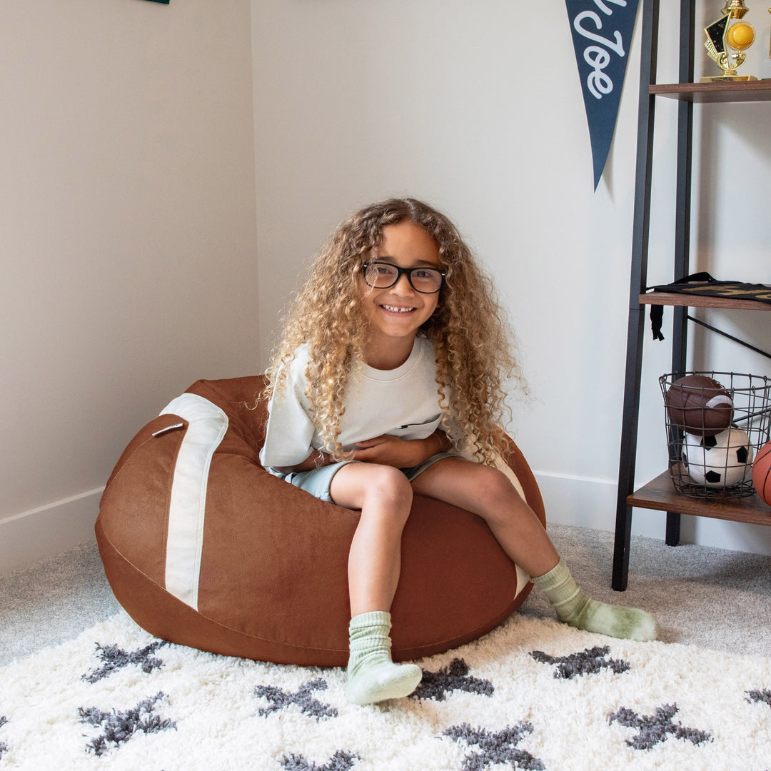 Football bean bag chair for kids with girl sitting