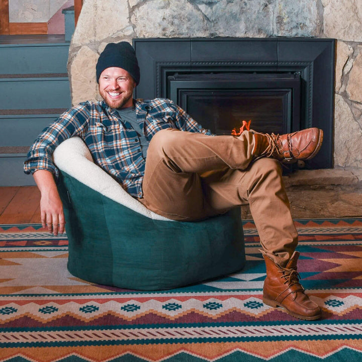 Man relaxing on cozy beanbag chair with arm and back rest #color_sage-sherpa-vegan-suede