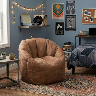 Brown bean bag chair in a room with a shelf, books, and posters on a blue wall. 