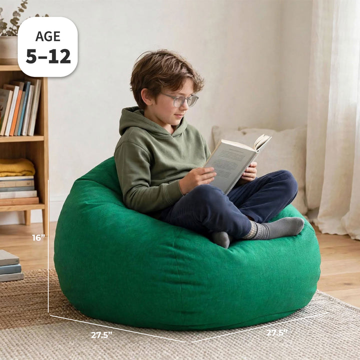 A child sitting on a large green bean bag chair in a bright room, reading a book. White dimension lines and text labels show the chair&