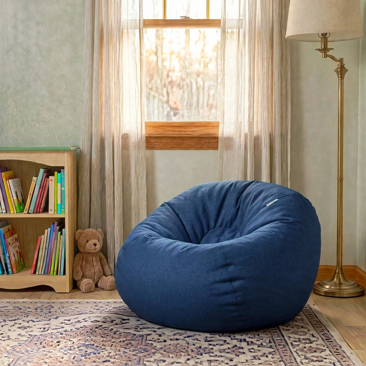 A large navy blue fabric bean bag chair in a cozy child&