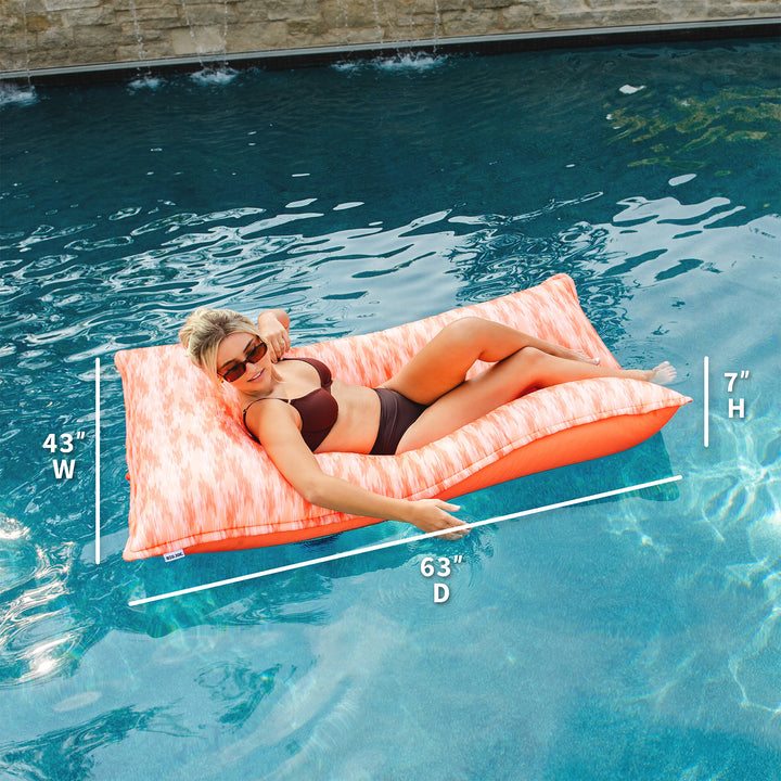 Woman lying on a pink pool float with measurements displayed, in a pool setting. #color_peach-glow