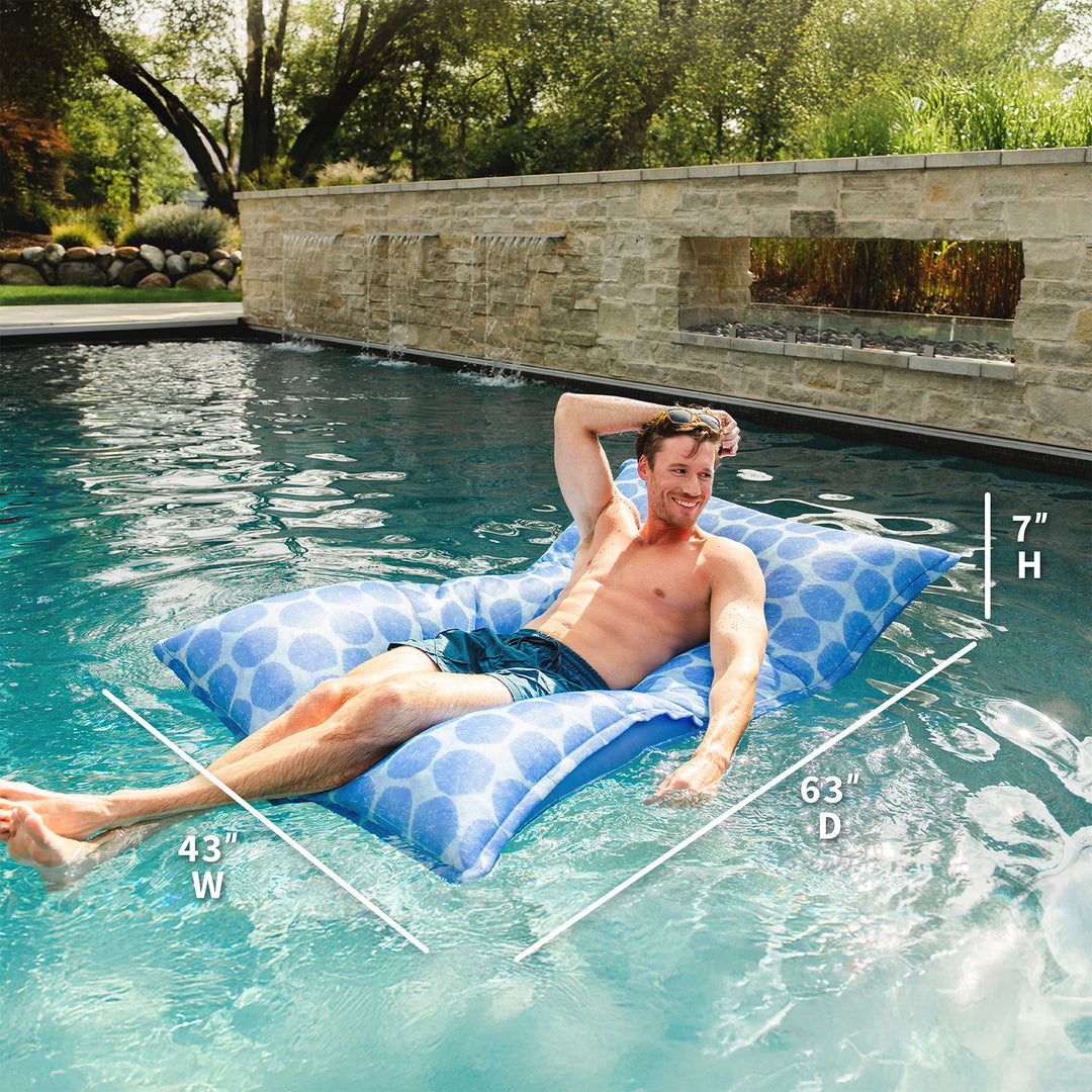 Man lying on a blue pool float in a pool with measurements displayed. #color_coral-bloom