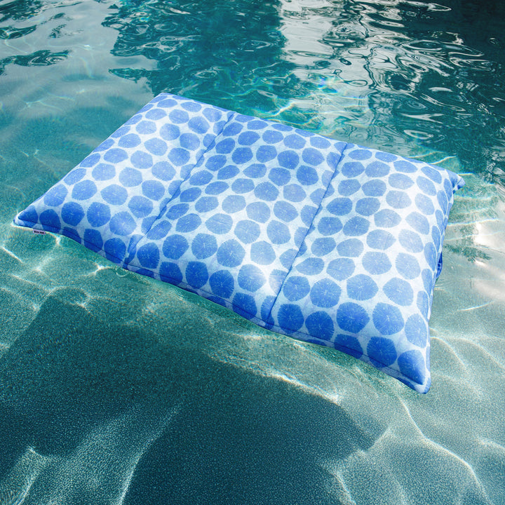 Blue polka dot pillow floating on water #color_coral-bloom