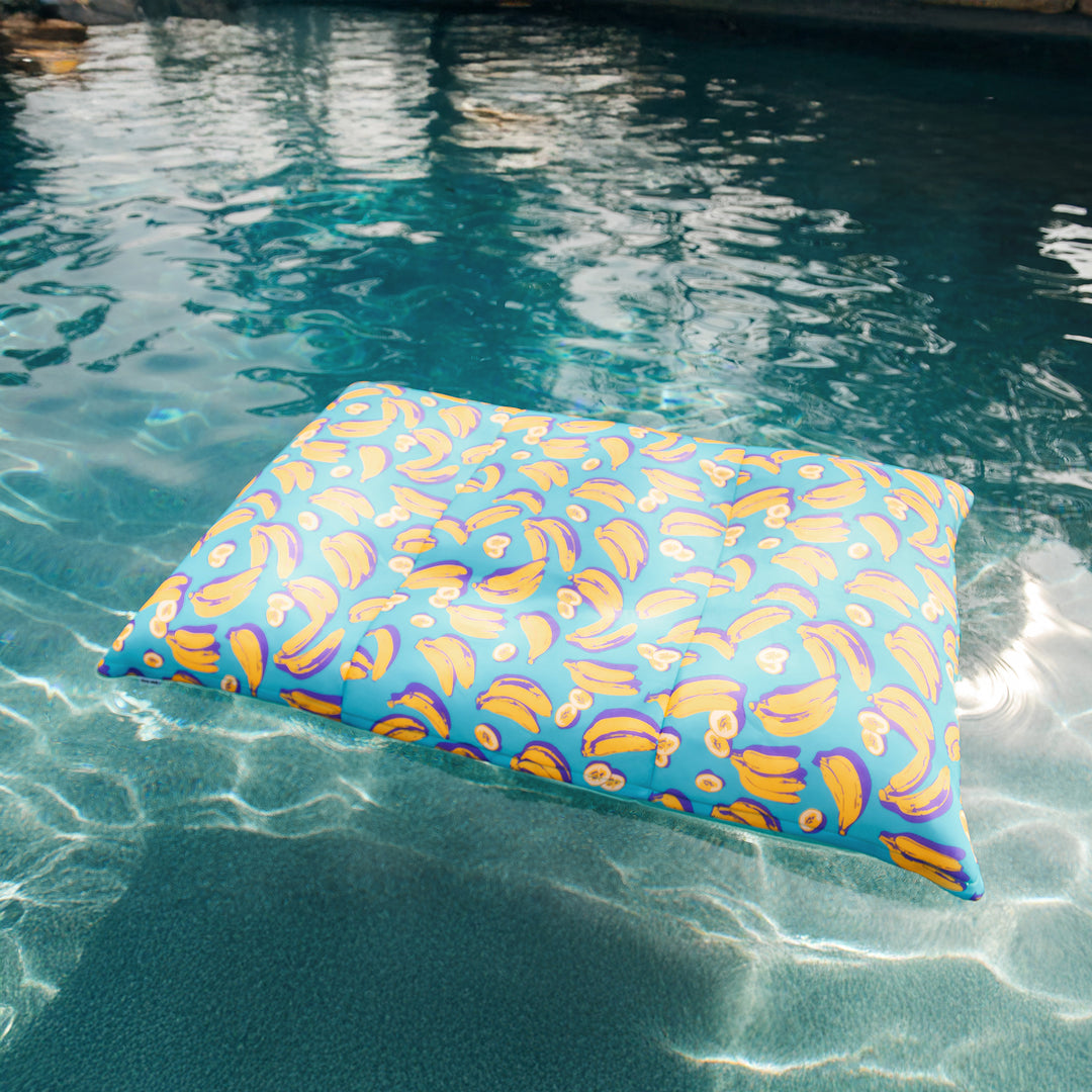 Colorful pool pillow floating in a pool #color_banana-pop