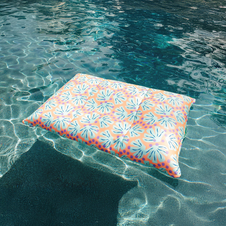 Floral-patterned pool floatie floating on clear water #color_sweet-shells-peach
