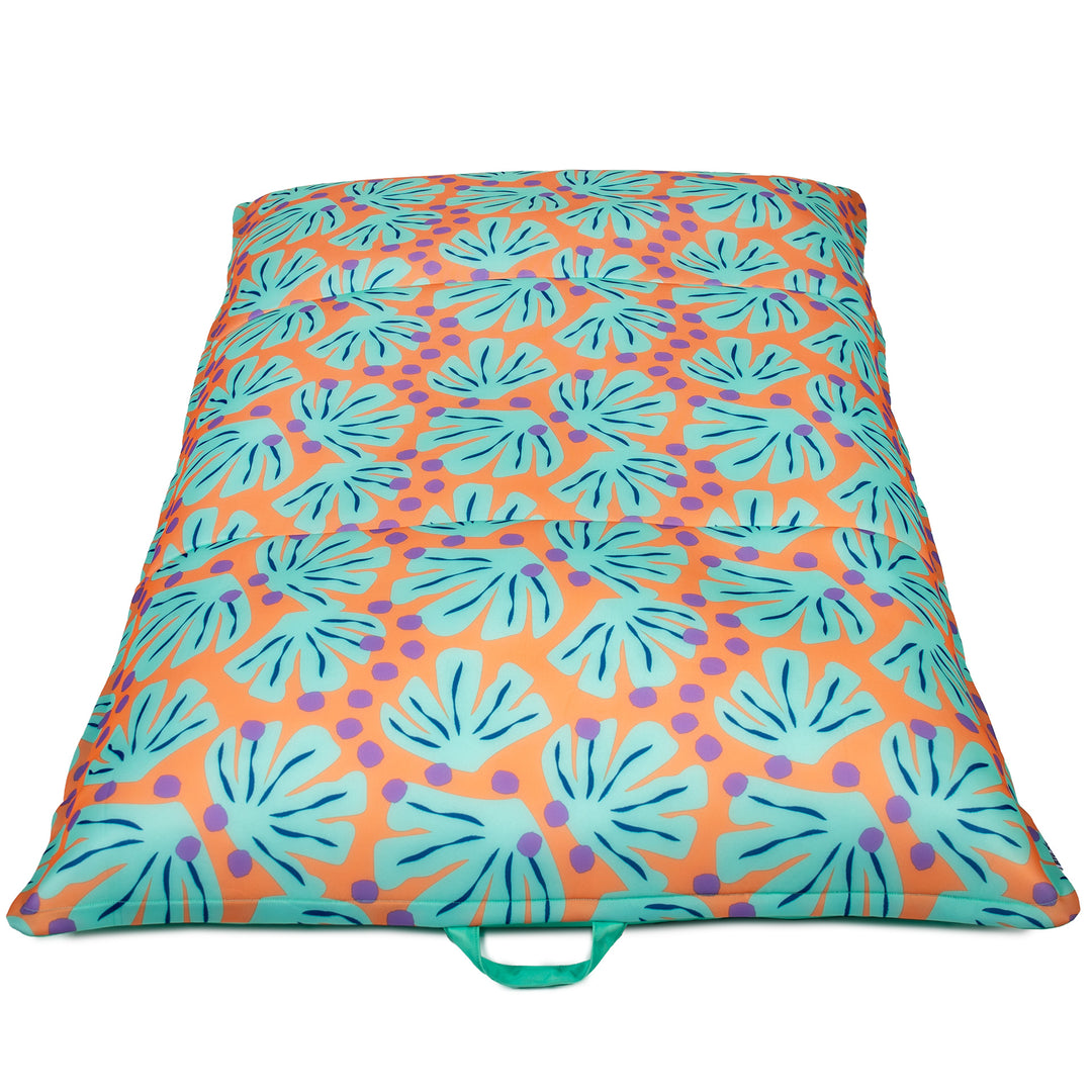 Colorful patterned seat pad with a handle on a white background #color_sweet-shells-peach