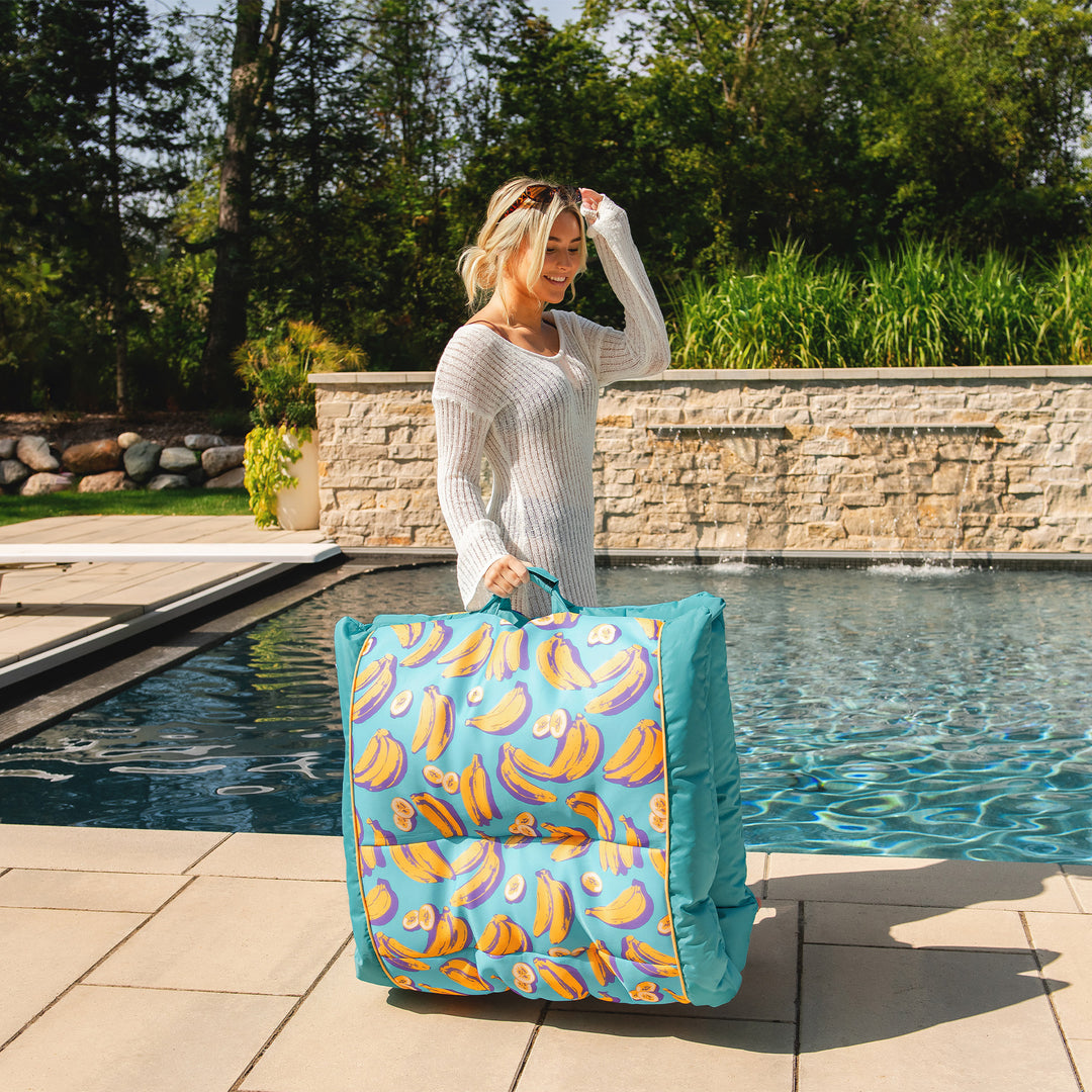 Woman holding a colorful pool float by a poolside #color_banana-pop