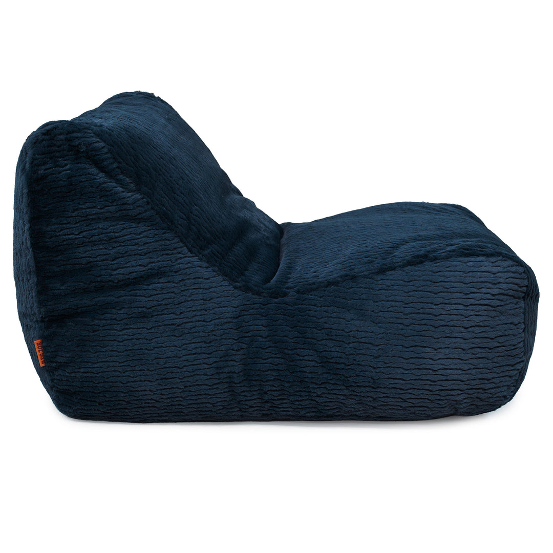 A dark navy blue textured bean bag chair with a wavy ribbed fabric, shown from a three-quarters angle on a solid white background. 