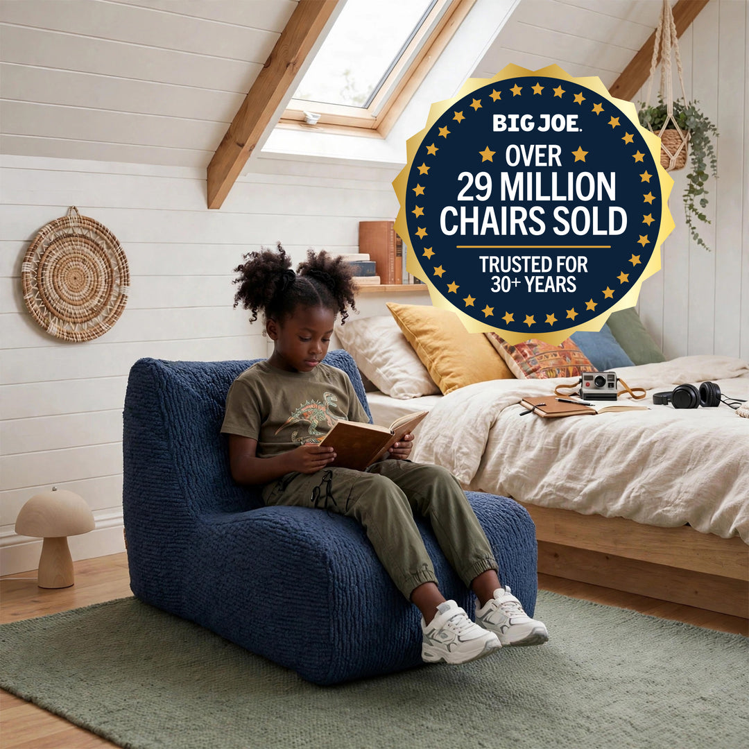 A child sits in a blue textured armchair reading in a bright bedroom, with a large promotional badge reading &