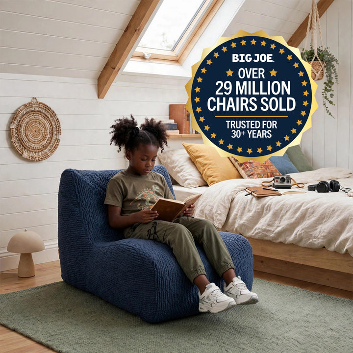 A child sits in a blue textured armchair reading in a bright bedroom, with a large promotional badge reading &