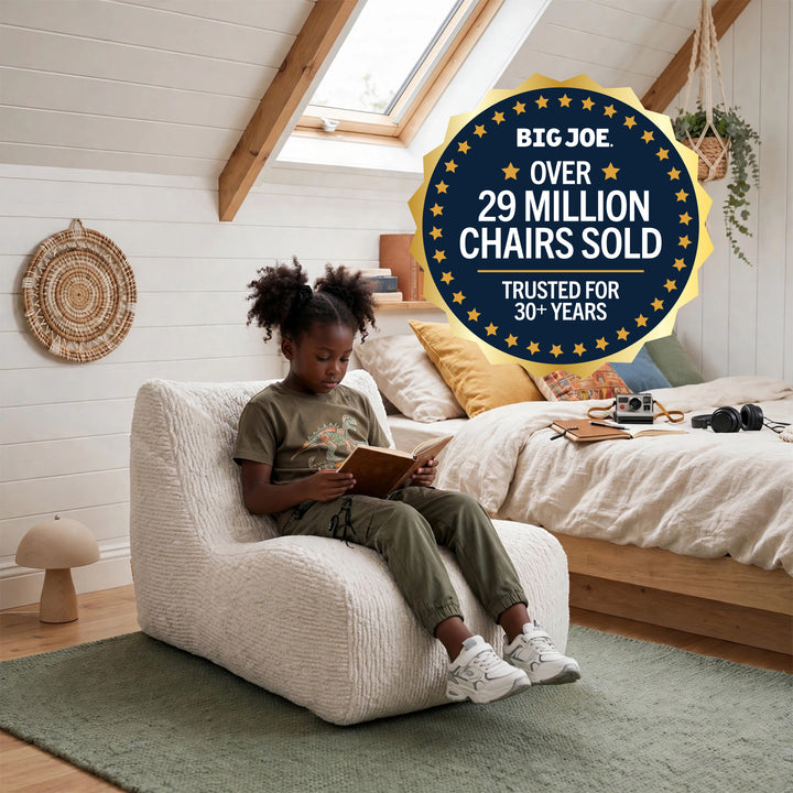 A child sits in a cream boucle lounge chair in a bright, modern bedroom. A large promotional badge in the top right reads &