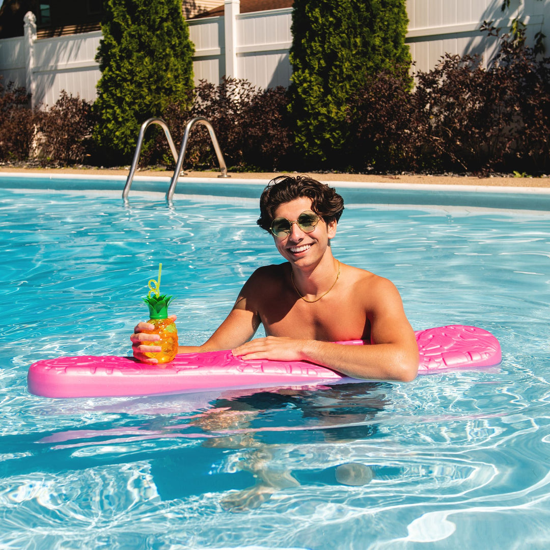 Man in pool with Aquaria Palm Drifter pool float #color_pink-palm