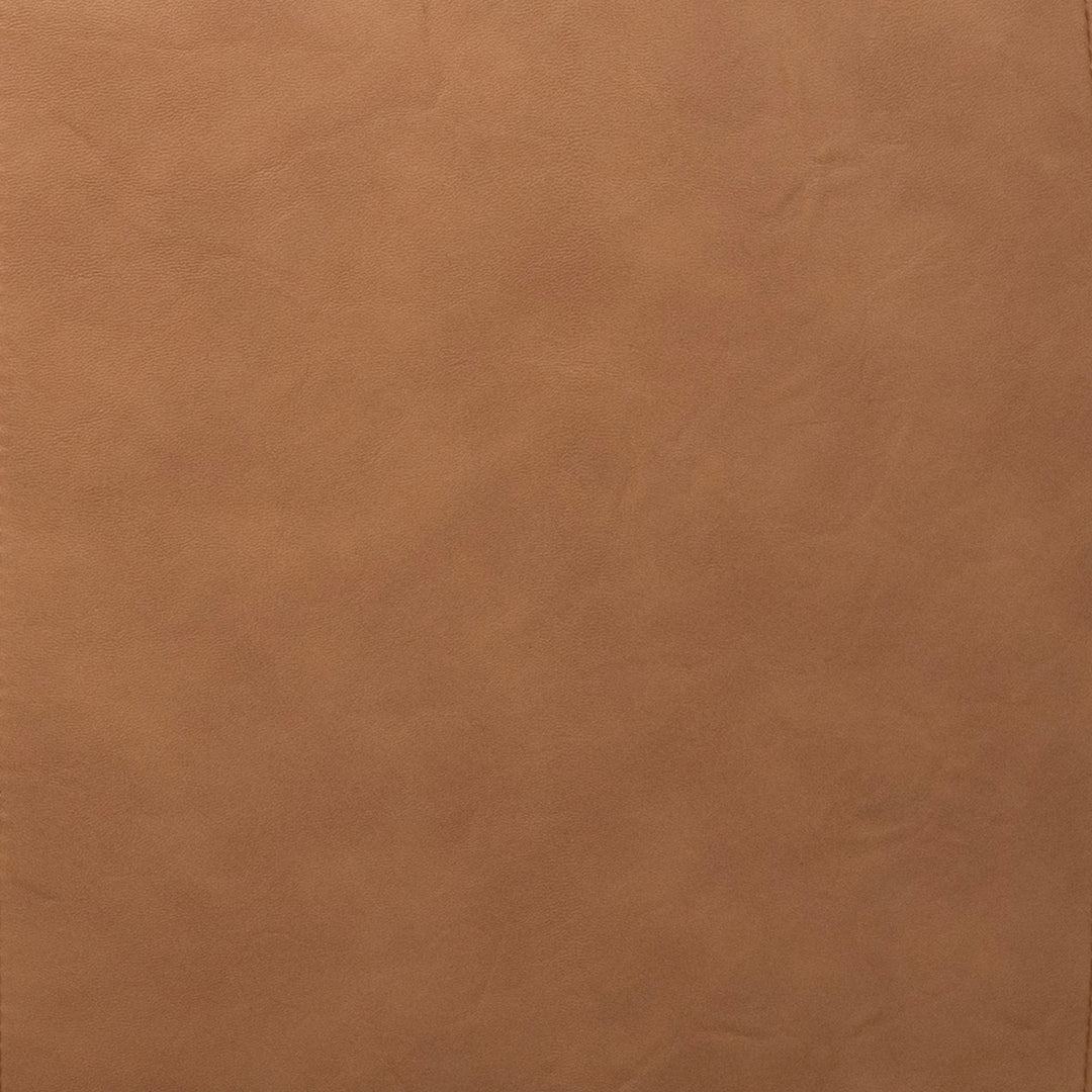 A close-up of a smooth, warm tan-brown textured material surface, resembling leather or faux leather. 