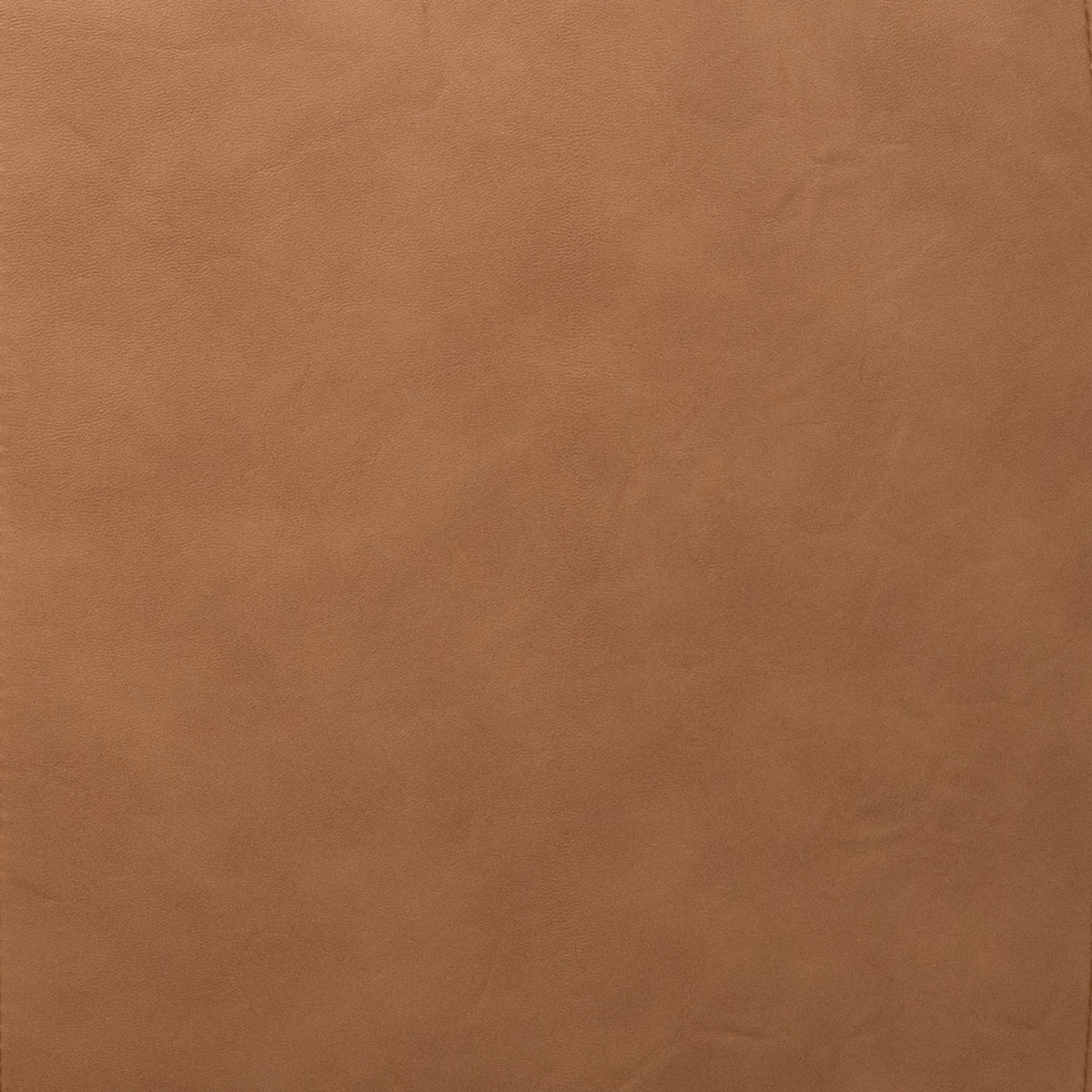 A close-up of a smooth, warm tan-brown textured material surface, resembling leather or faux leather. 