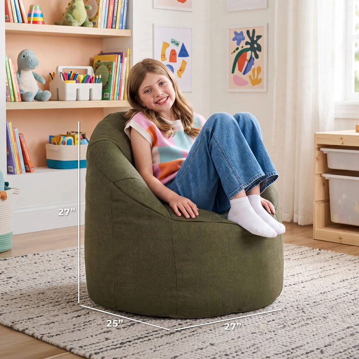 A child sits on a large olive green bean bag chair in a bright children&