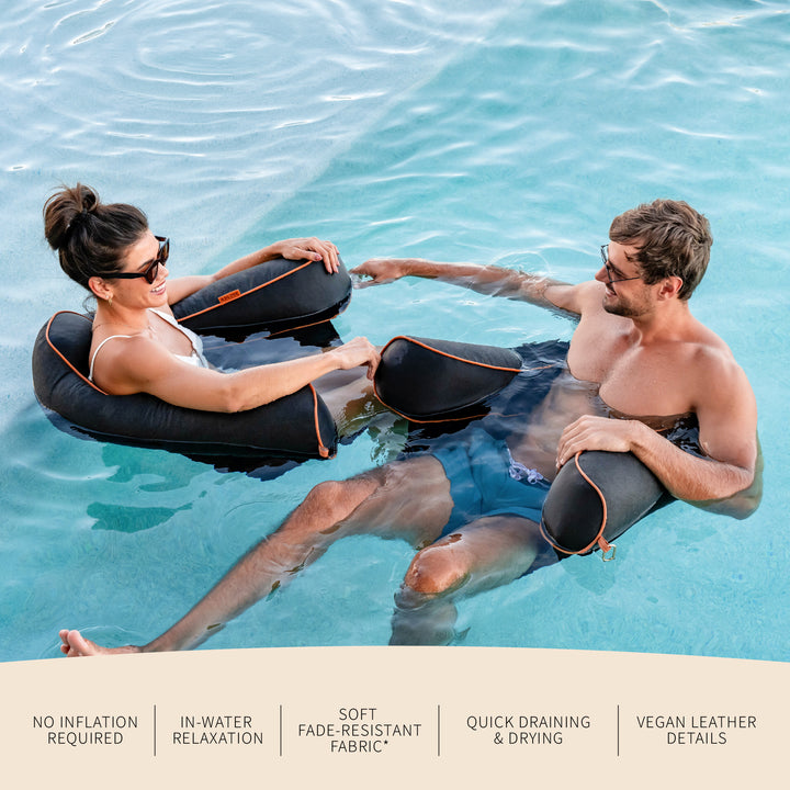 Two people relaxing in water with pool seats, surrounded by water. #color_twilight-sunbrella-fabric