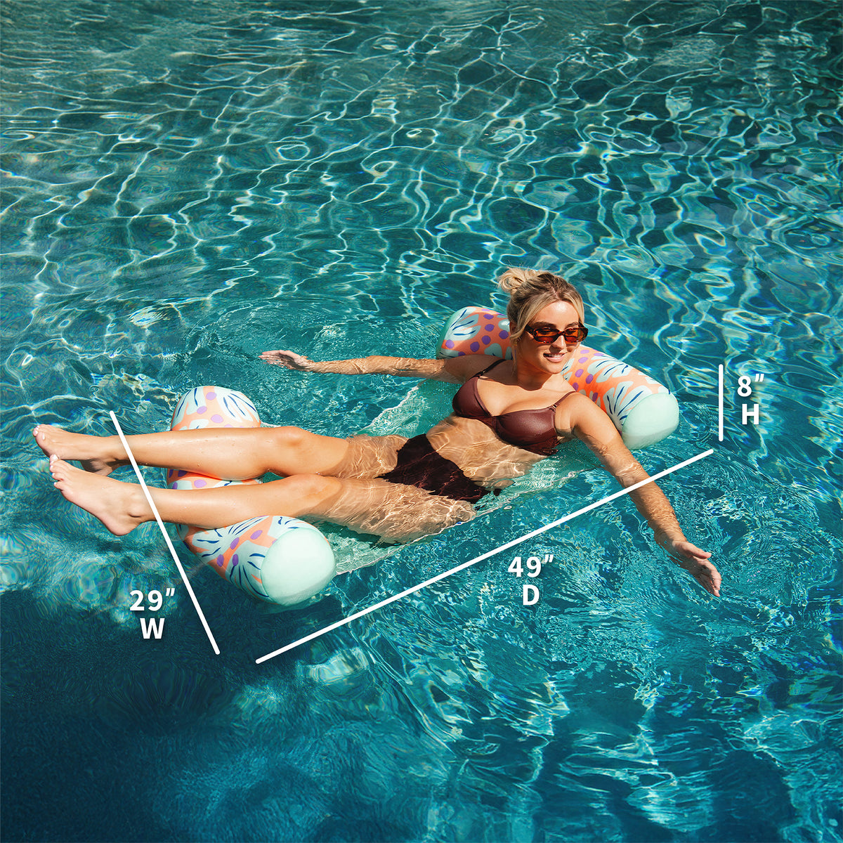 Woman floating on a pool floatie in clear blue water with measurements overlaid. 