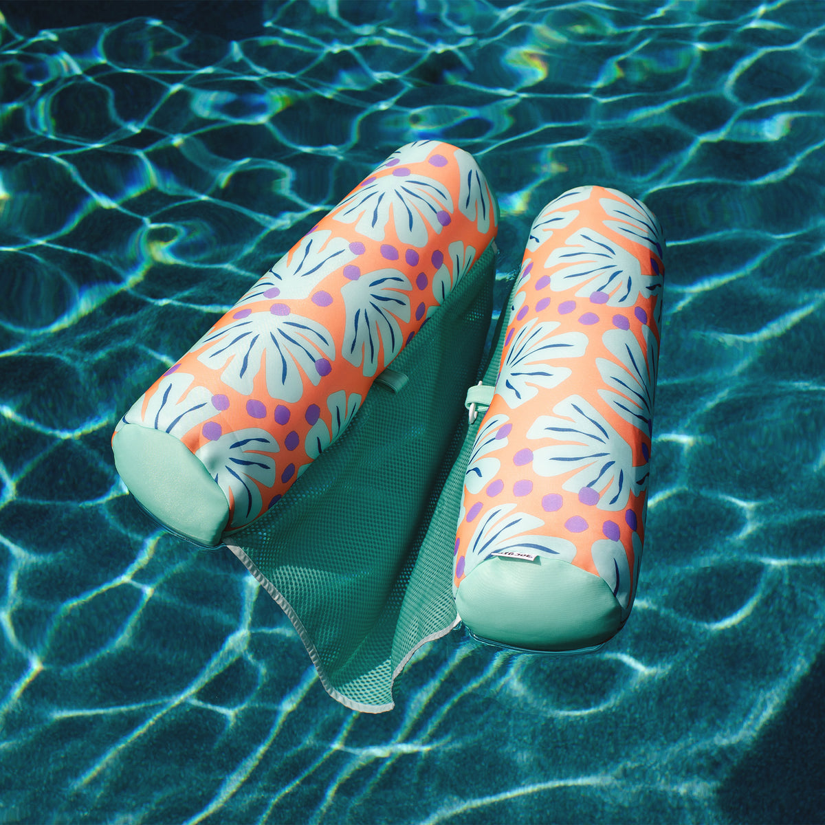 Two colorful pool floats on a pool surface 