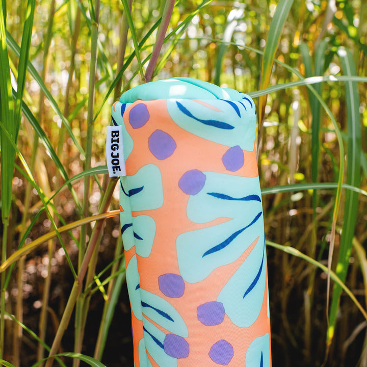 Colorful pool float with leaf pattern and 'BIG JOE' tag in a grassy background #color_sweet-shells-peach