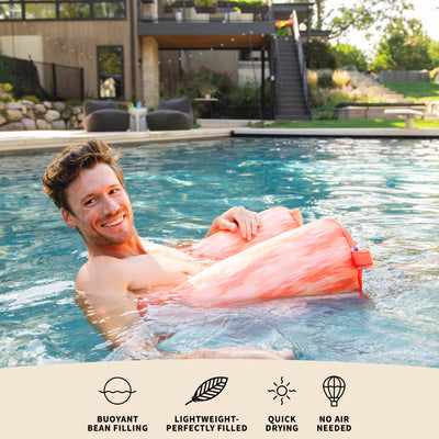 Man floating on a pink pool float in a swimming pool with text about product features. 