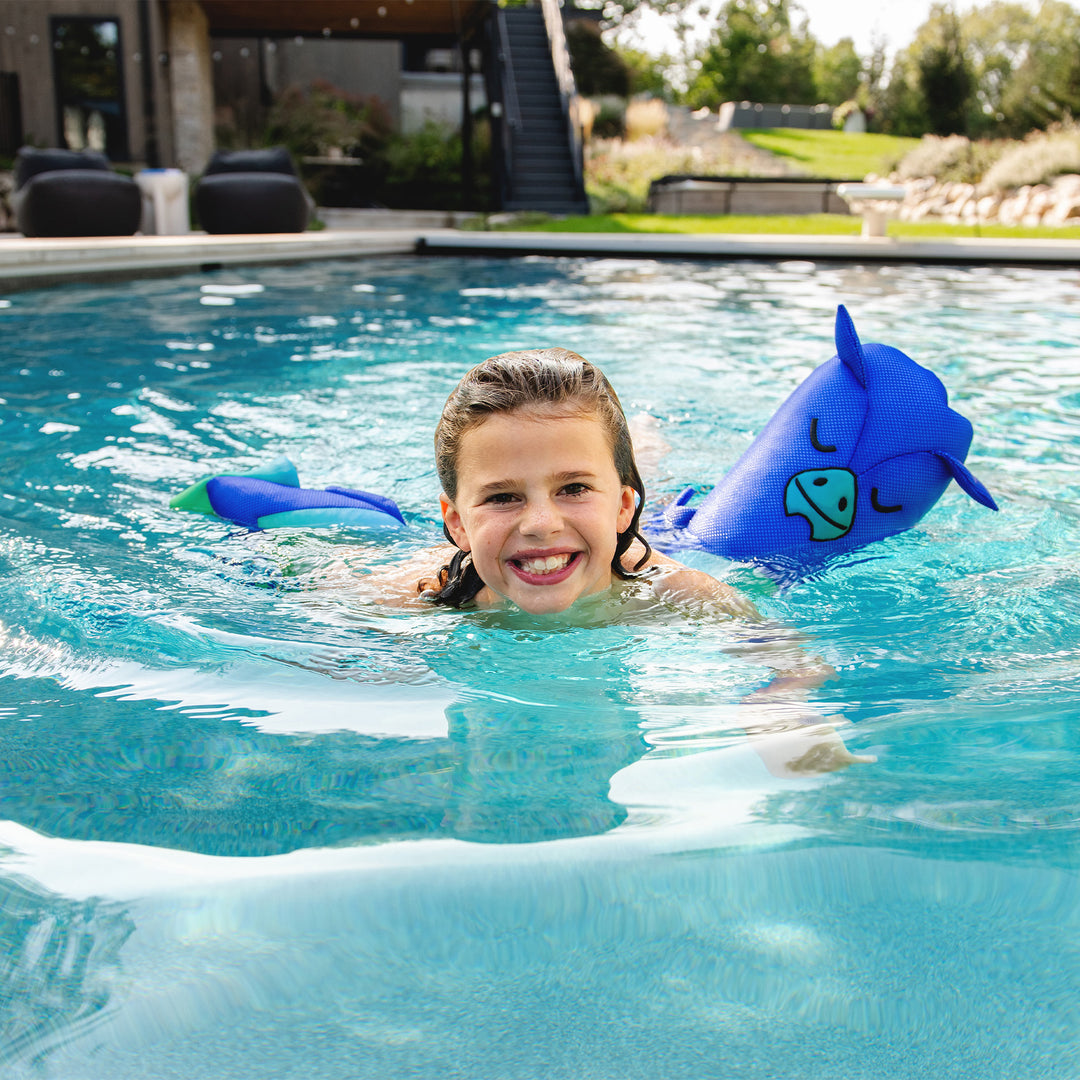 Child swimming in a pool with blue inflatable dragon toys #style_dragon