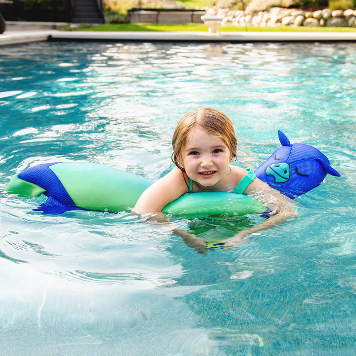 Child swimming with green and blue pool floats in a pool #style_dragon