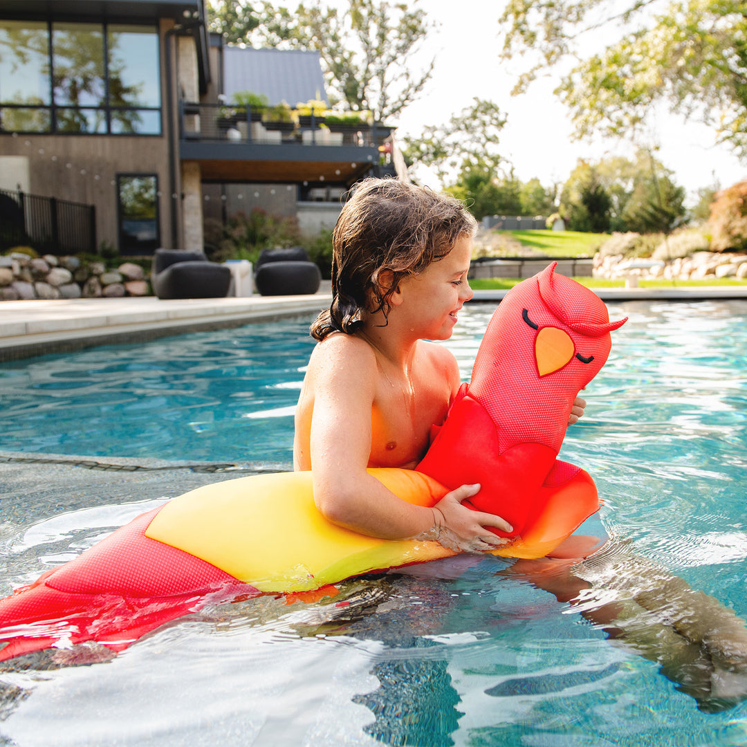 Child playing in a pool with a colorful bean noodle pool toy #style_phoenix