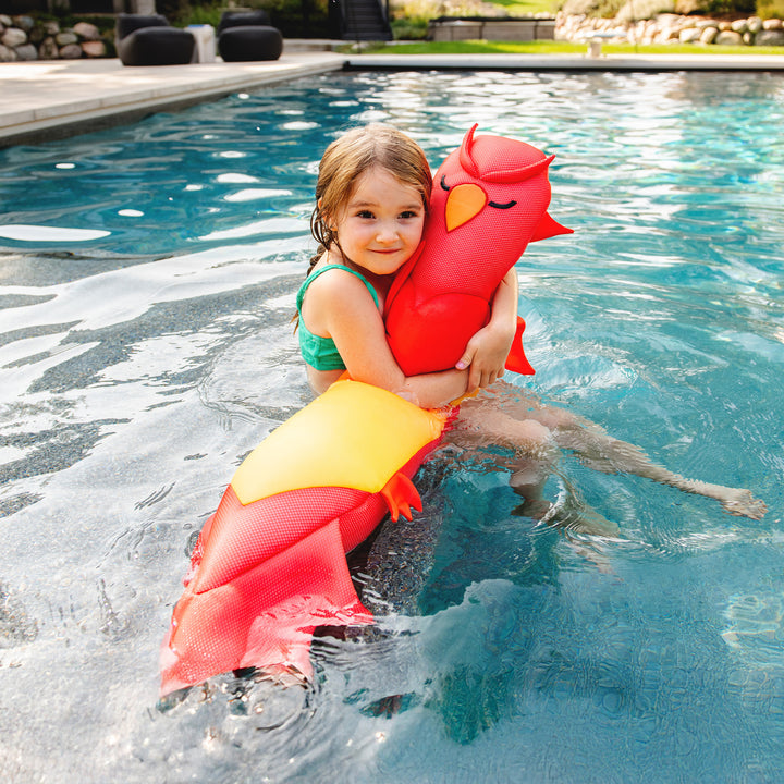 Child holding a red and yellow phoenix pool float noodle in a pool #style_phoenix