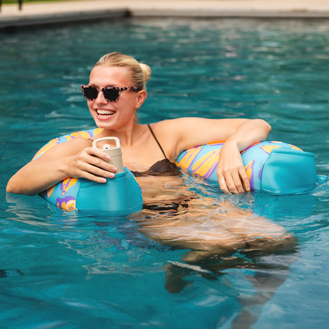 Woman in a pool with a colorful pool sling and drink. #color_banana-pop