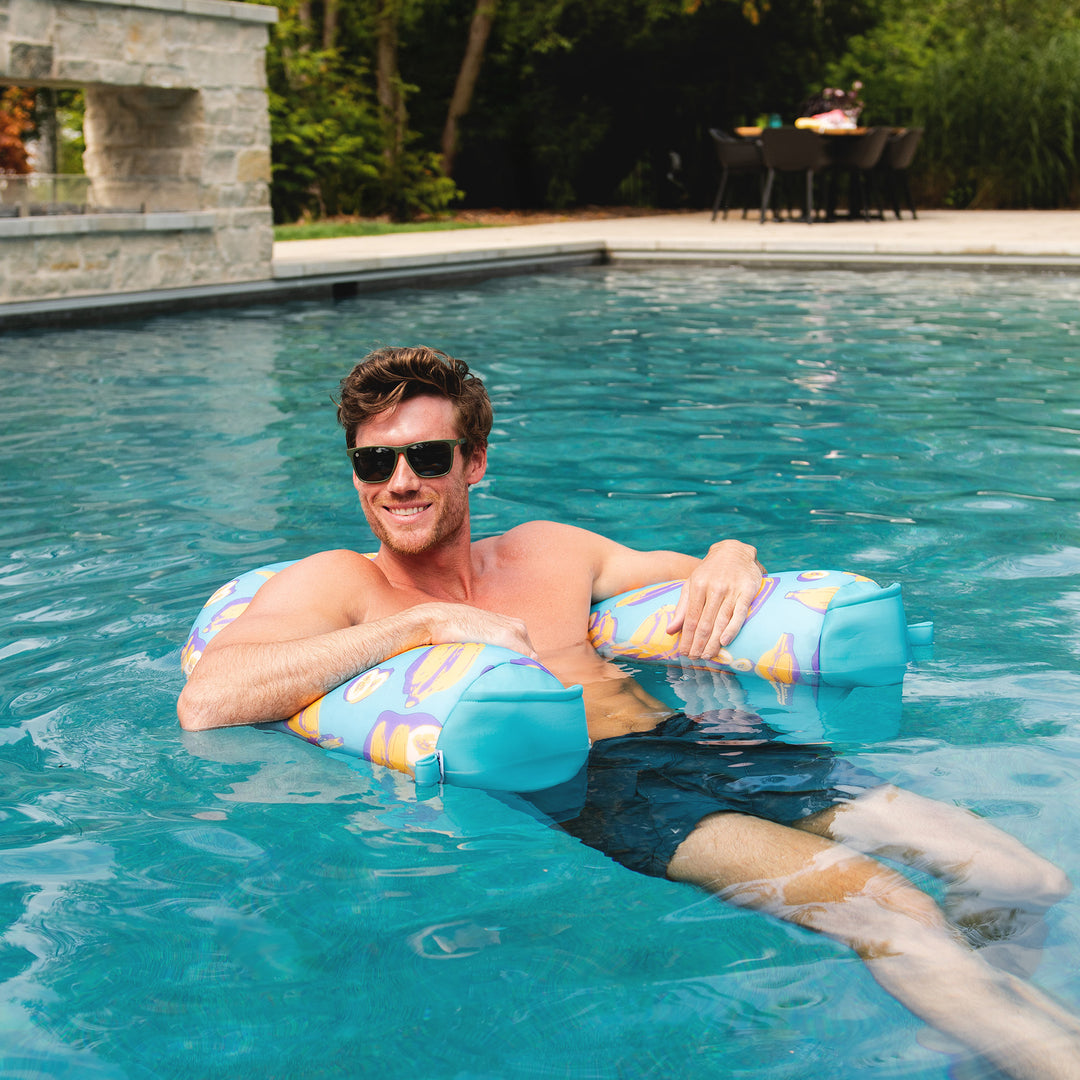 Man relaxing on a colorful pool float in a swimming pool. #color_banana-pop