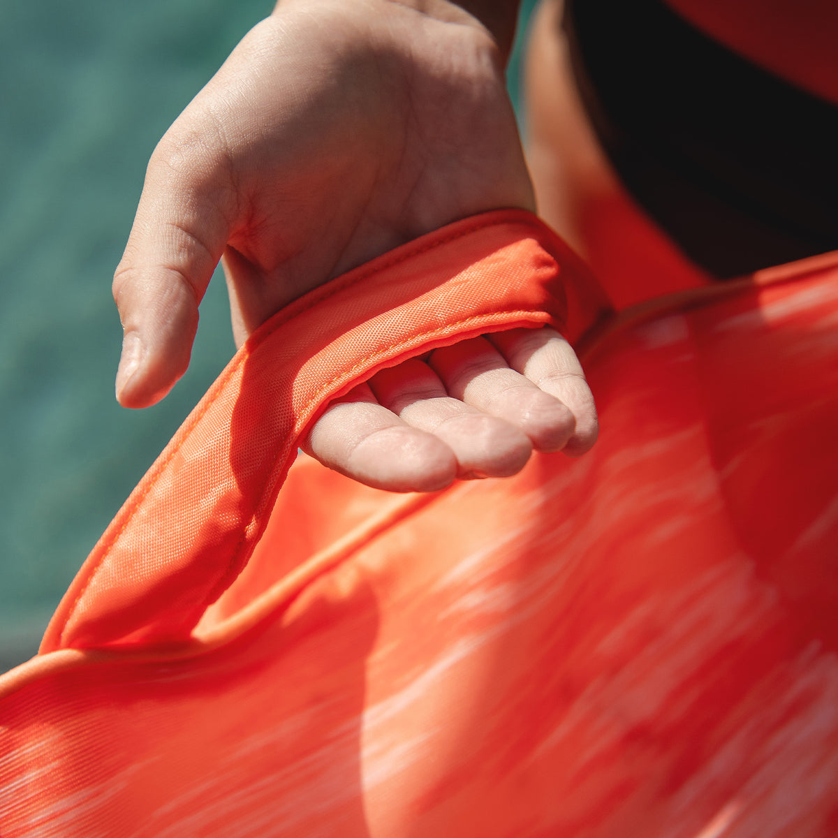 Close-up of a person wearing an orange pool float with a blurred background 