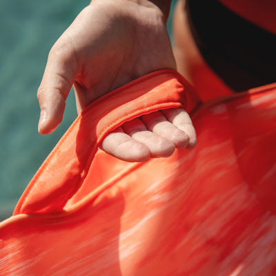 Close-up of a person wearing an orange pool float with a blurred background 