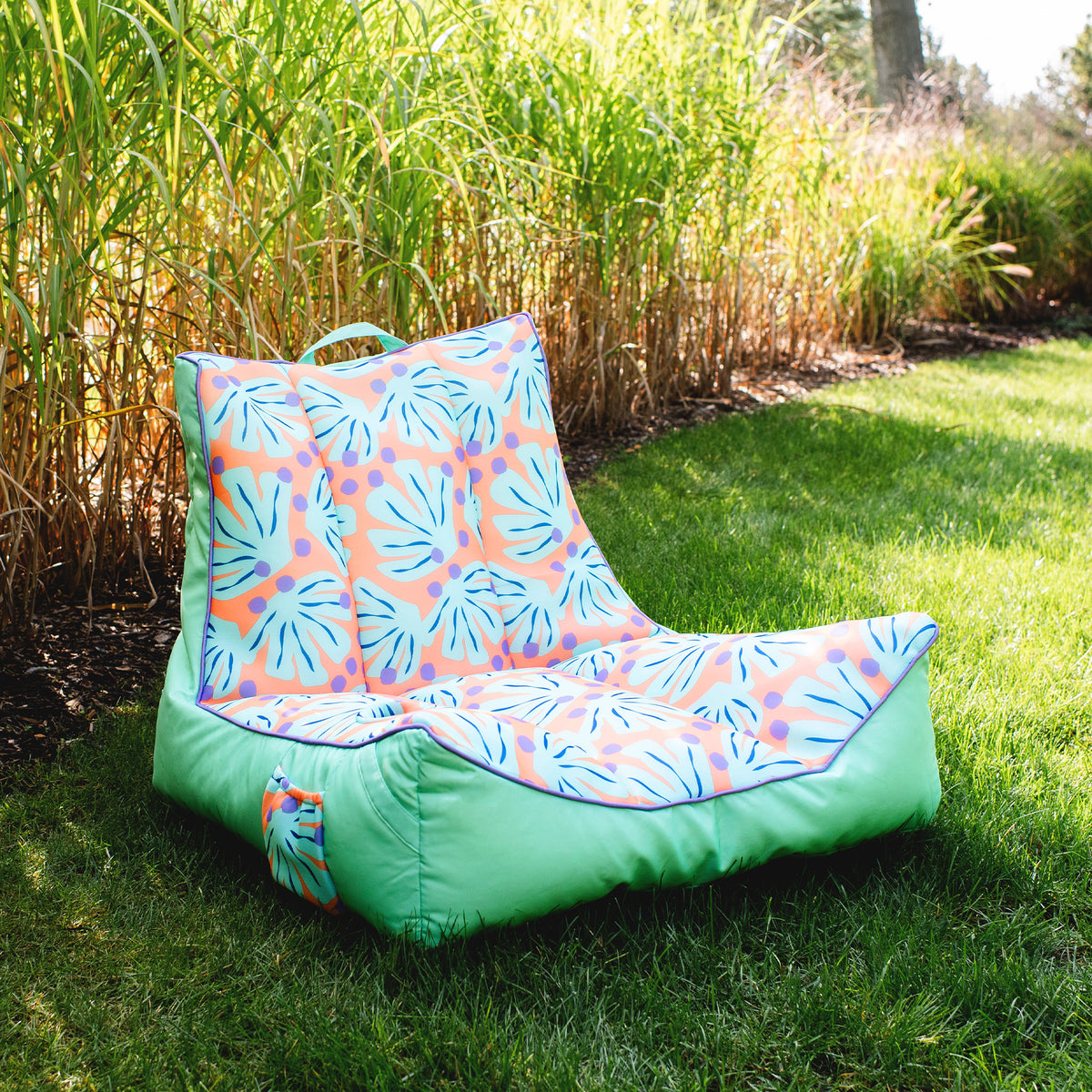 Colorful outdoor chair with floral pattern on grass 