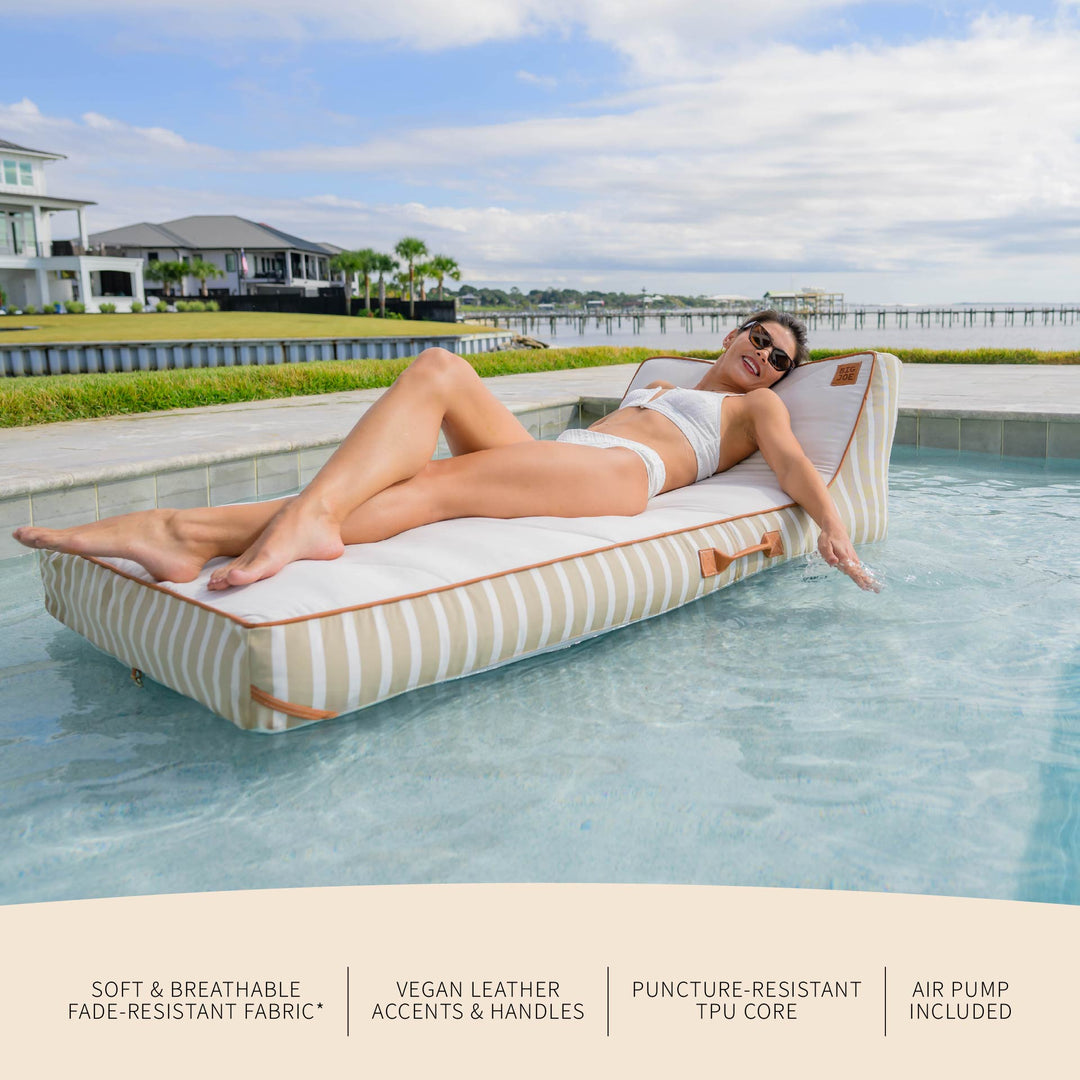 Woman lounging on a striped pool float in a pool with text detailing features. #color_sand-stripe-sunbrella-fabric