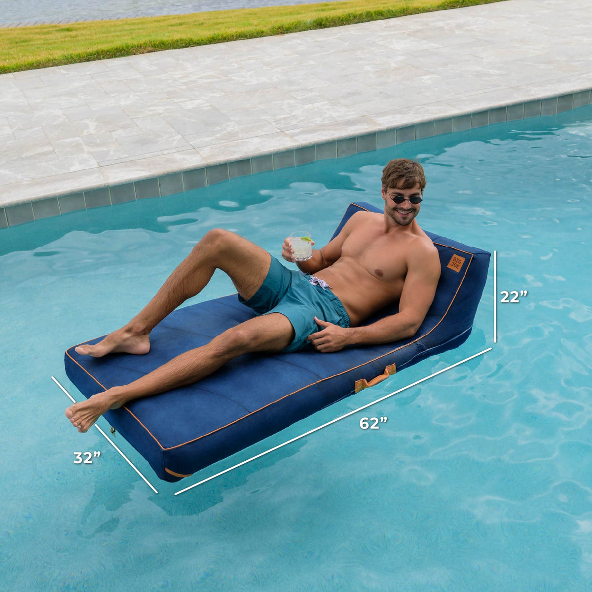 Man lounging on a blue inflatable pool float with dimensions displayed, by a pool. 