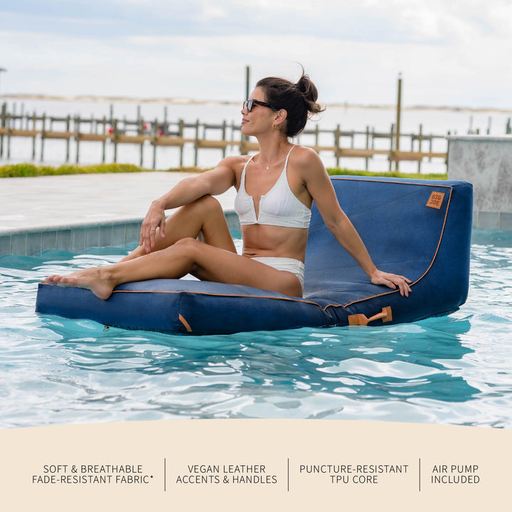Woman sitting on a blue inflatable pool float in a pool with text about product features. #color_harbor-blue-sunbrella-fabric