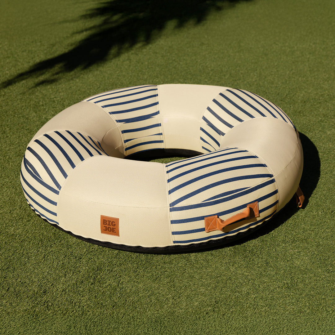 Lux inflatable pool ring with fabric cover shown on the grass #color_navy-and-ivory-stripe