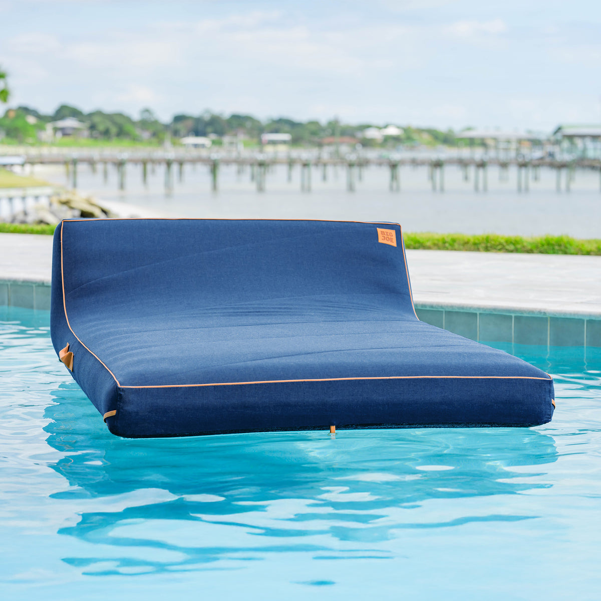 Blue inflatable pool floatie in a swimming pool with a scenic background 