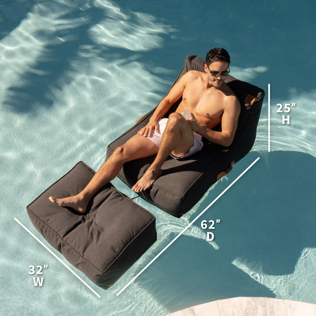 Man lounging on a black pool lounger with dimensions displayed, set against a pool background. 