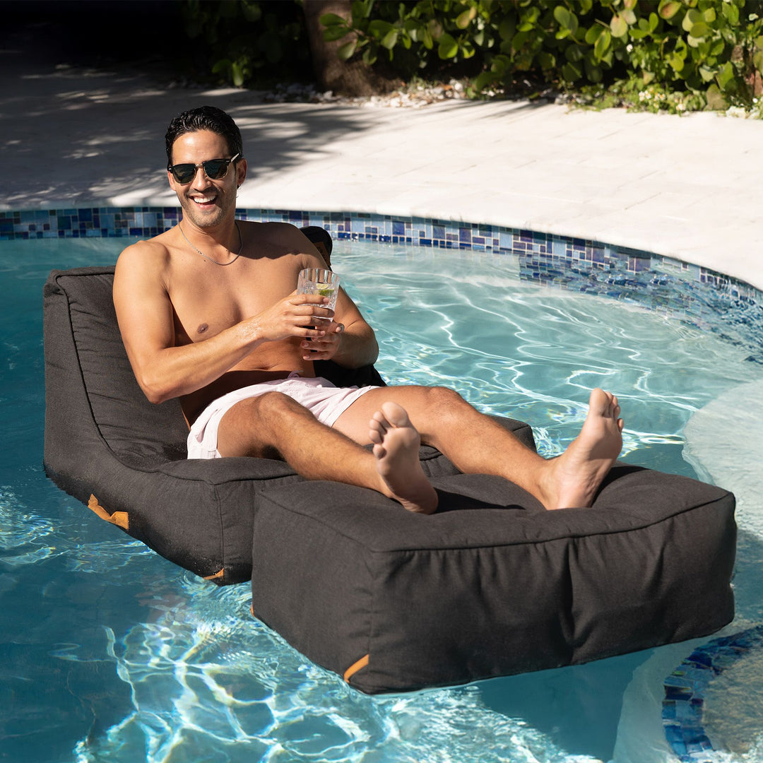 man relaxing in the sun and pool on the sealander Lux Sealander Pool Lounger #color_twilight-sunbrella-fabric