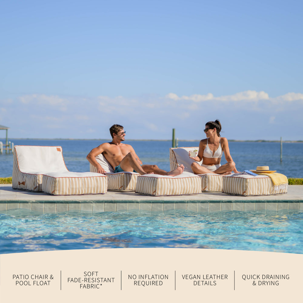 Two people sitting on patio chairs by a pool with ocean view #color_sand-stripe-sunbrella-fabric