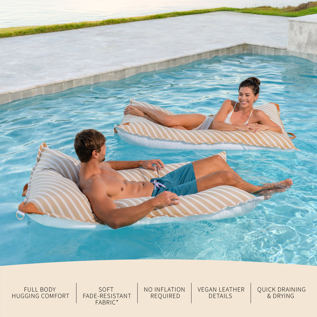 Two people relaxing on inflatable lounge chairs in a pool. 