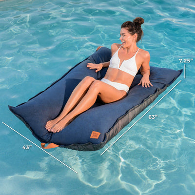 Woman sitting on a blue inflatable lounge in clear blue water with measurements displayed. 